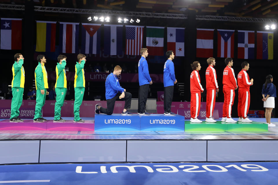 Fencing gold medalist Race Imboden of the United States takes a knee during the national anthem at the Pan American Games on Aug. 9, 2019, in Lima, Peru. (Photo: Leonardo Fernandez via Getty Images)