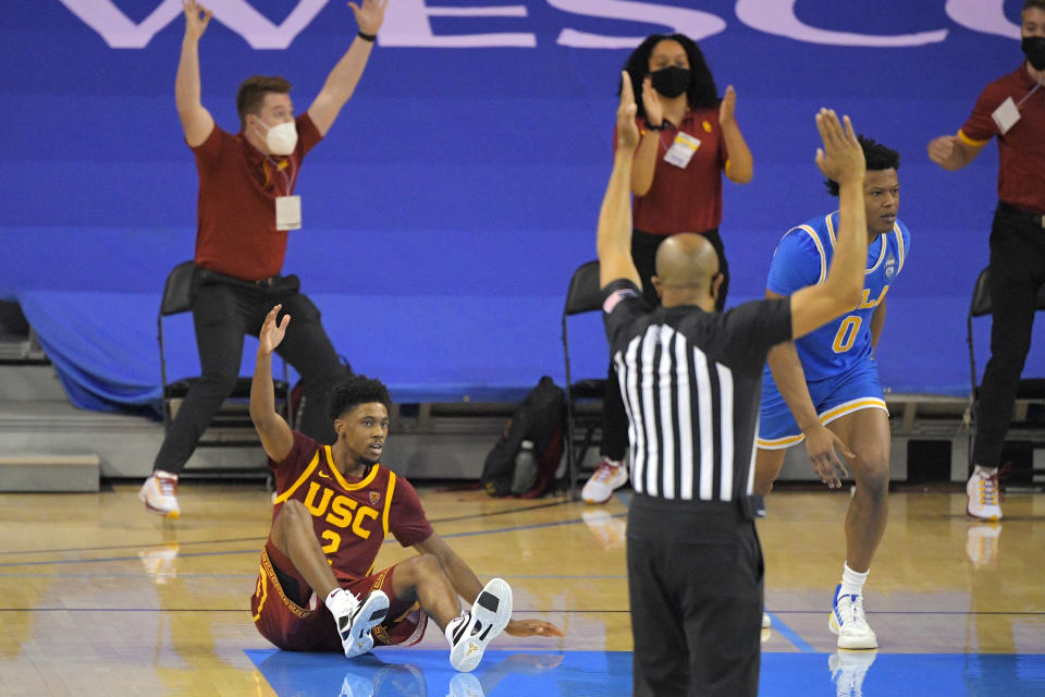 Southern California guard Tahj Eaddy, left, reacts after making a game-winning three-point shot as UCLA guard Jaylen Clark runs down court during the second half of an NCAA college basketball game Saturday, March 6, 2021, in Los Angeles. USC won 64-63. (AP Photo/Mark J. Terrill)