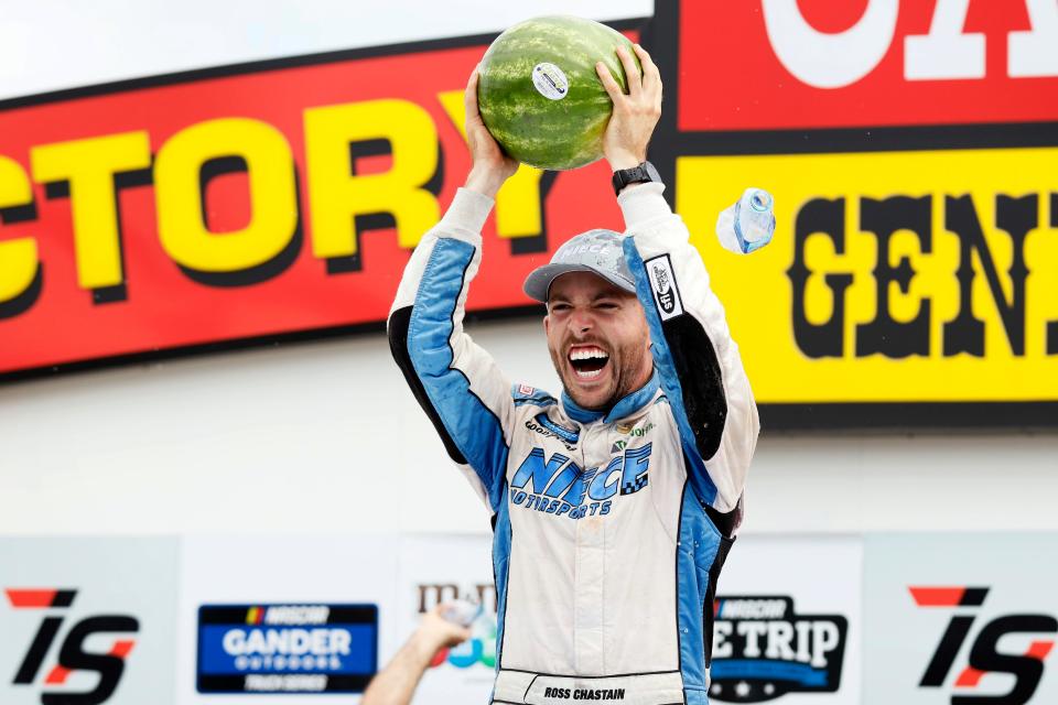 Ross Chastain hoists a watermelon in Iowa Speedway's victory lane after winning the M&M's 200.