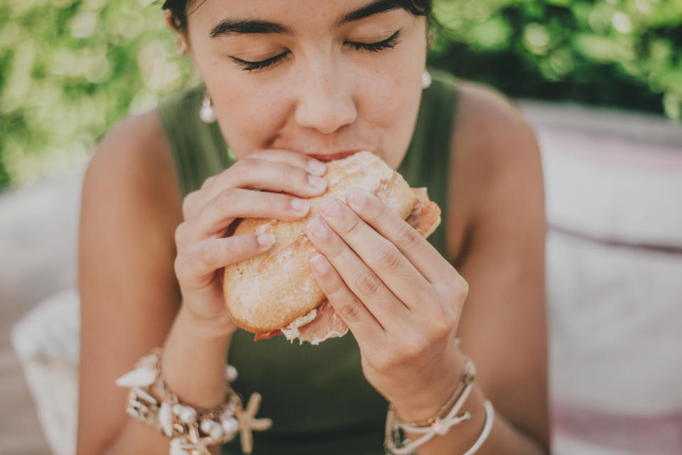 person biting into a sandwich and chewing