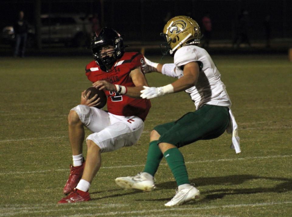 Creekside quarterback Sean Ashenfelder (2) tries to sidestep Fleming Island's Sebastian Cruz (9).