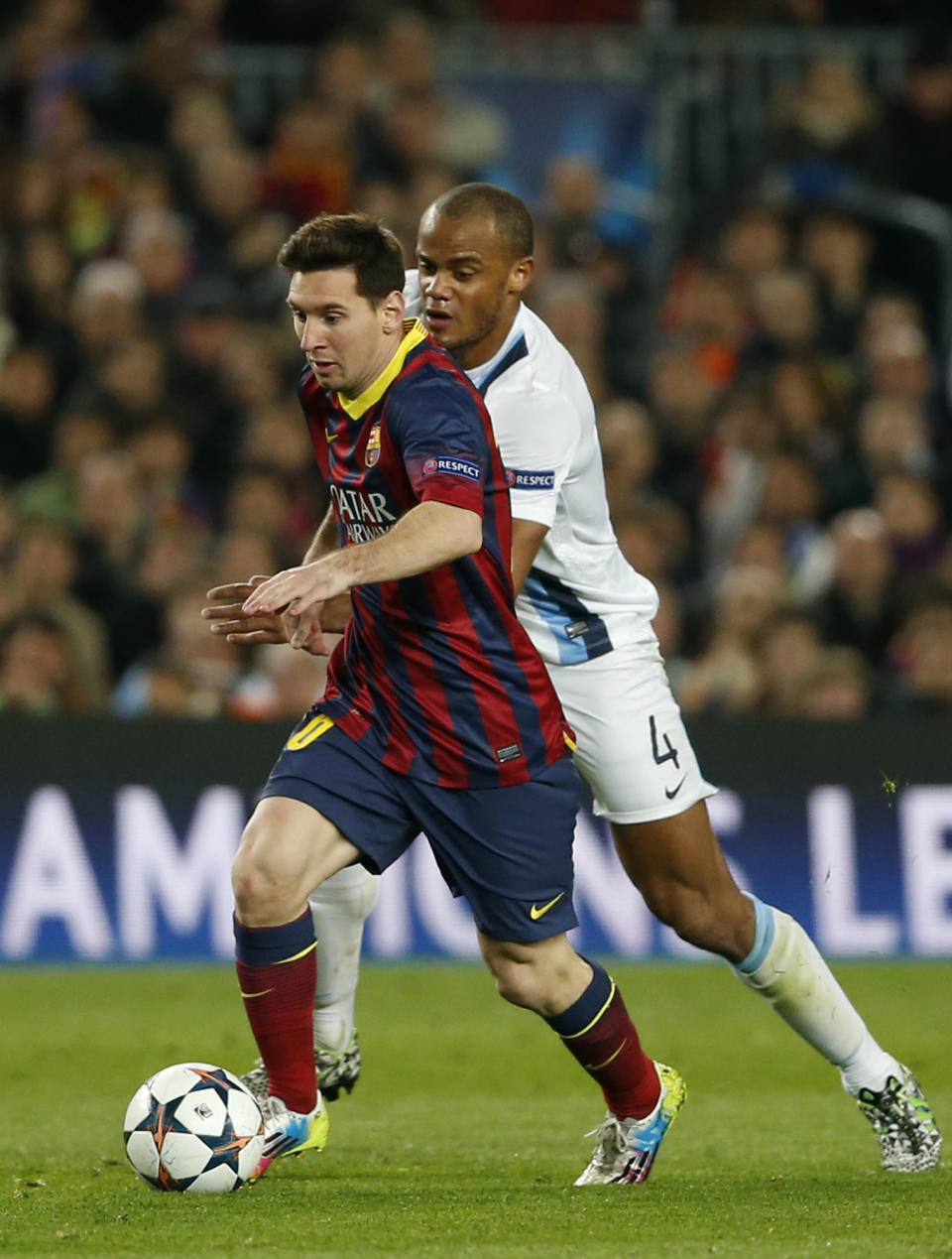 Barcelona's Lionel Messi, left is chased by Manchester City's Vincent Kompany during a Champions League, round of 16, second leg, soccer match between FC Barcelona and Manchester City at the Camp Nou Stadium in Barcelona, Spain, Wednesday March 12, 2014. (AP Photo/Emilio Morenatti)