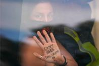 An activist from the Extinction Rebellion climate change group shows a message written on her hand as she is taken away in a police van after being arrested for locking herself to railings outside UK's parliament in central London on September 10, 2020 on the final day of their new series of 'mass rebellions'. - Climate change protesters have put on 10 days of demonstrations, held across the country by activist group Extinction Rebellion. (Photo by Niklas HALLE'N / AFP) (Photo by NIKLAS HALLE'N/AFP via Getty Images)