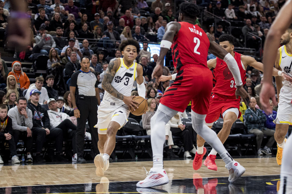 Utah Jazz guard Keyonte George (3) drives against Portland Trail Blazers center Deandre Ayton (2) during the second half of an NBA basketball game Saturday, Dec. 2, 2023, in Salt Lake City. (AP Photo/Isaac Hale)