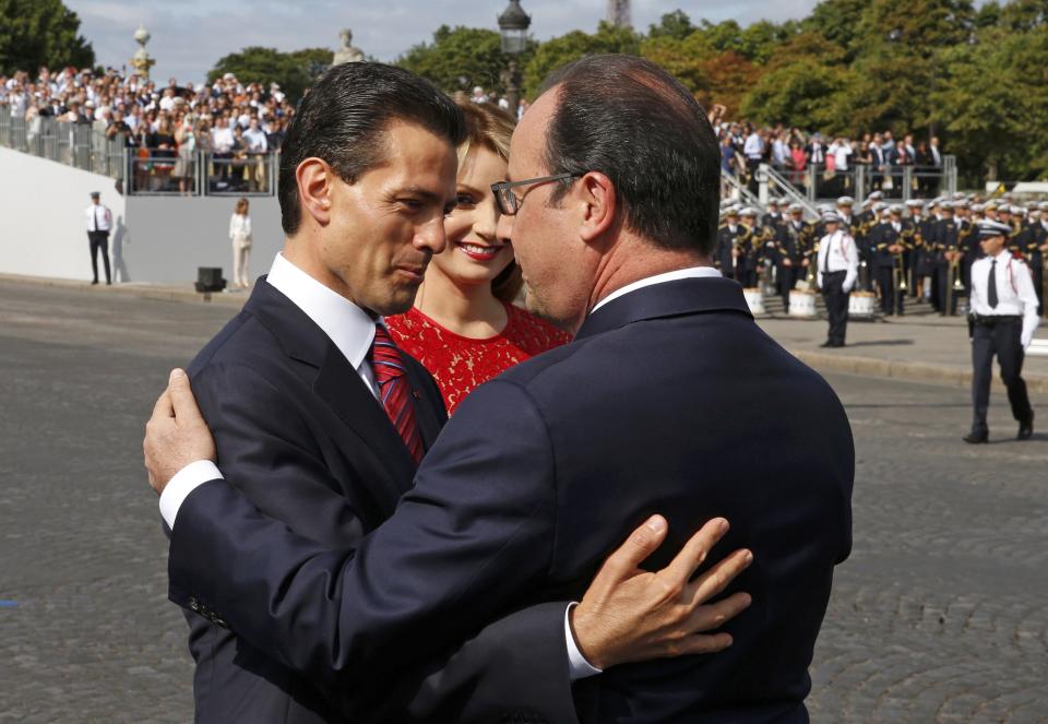 French President Francois Hollande greets Mexico's President Enrique Pena Nieto and Mexico's First Lady Angelica Rivera at the start of the traditional Bastille Day military parade in Paris