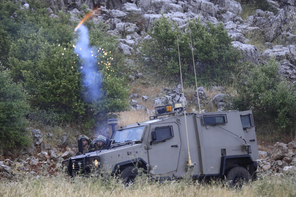 Israeli troops fire tear gas at protesters on the outskirts of the Lebanese border village of Kfar Chouba, south Lebanon, Friday, June 9, 2023. Israeli soldiers fired tear gas to disperse scores of protesters who pelted the troops with stones along the border with Lebanon Friday, leaving some Lebanese demonstrators and troops suffering breathing problems. (AP Photo/Mohammad Zaatari)