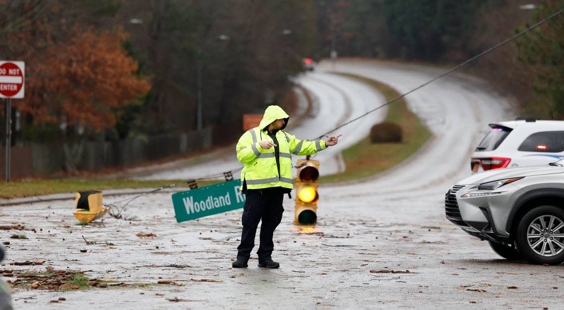 Garner police direct traffic off Timber Drive at Woodland Road after a storm knocked down limbs and traffic lights in Garner, N.C., Sunday, Dec. 10, 2023.