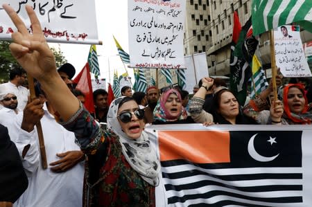 People chant slogans as they hold the representation of Kashmir's flags during a rally expressing solidarity with the people of Kashmir, in Karachi