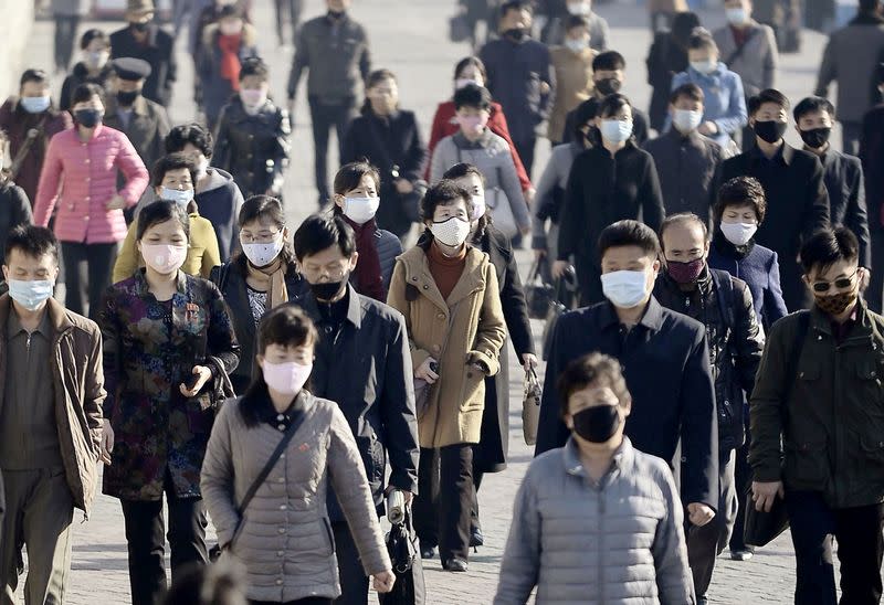 FILE PHOTO: People wearing protective face masks commute amid concerns over the new coronavirus disease in Pyongyang, North Korea