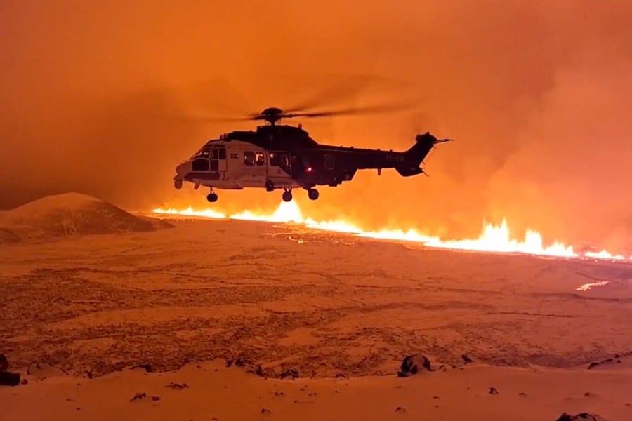 This image made from video provided by the Icelandic Coast Guard shows its helicopter flying near magma running on a hill near Grindavik on Iceland’s Reykjanes Peninsula sometime around late Monday, Dec. 18, or early Tuesday, Dec. 19, 2023. A volcanic eruption started Monday night on Iceland’s Reykjanes Peninsula, turning the sky orange and prompting the country’s civil defense to be on high alert. (Icelandic coast guard via AP)