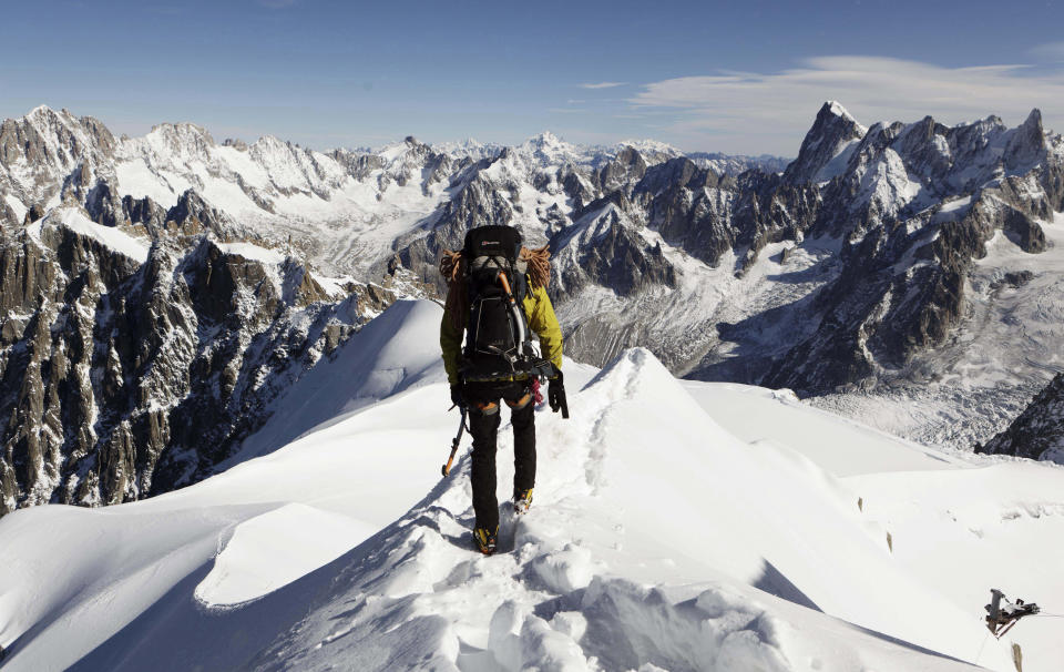 FILE - An Alpinist heads down a ridge on the Aiguille du Midi (3,842 meters; 12 605 feet), towards the Vallee Blanche on the Mont Blanc massif, in the Alps, near Chamonix, France. The Olympic torch finally enters France when it reaches the southern seaport of Marseille on Wednesday May 8, 2024, on an armada from Greece. After leaving Marseille a vast relay route will be undertaken, including a sweep up the Chamonix-Mont-Blanc mountain pass, before the torch's odyssey ends on July 27 in Paris. (AP Photo/David Azia,File)