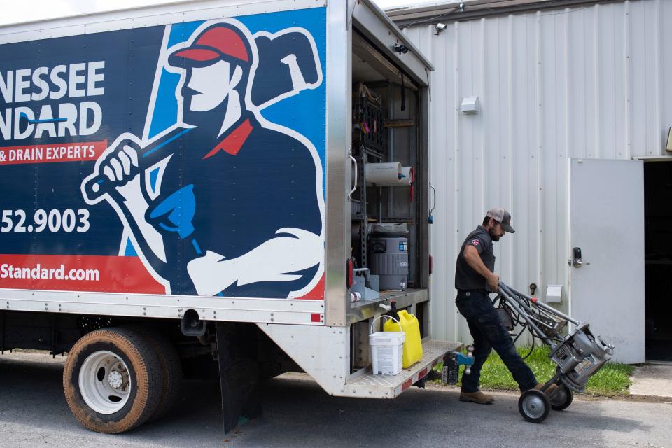 Jacob Wiser unloads equipment at the Tennessee Standard Plumbing headquarters on May 29.