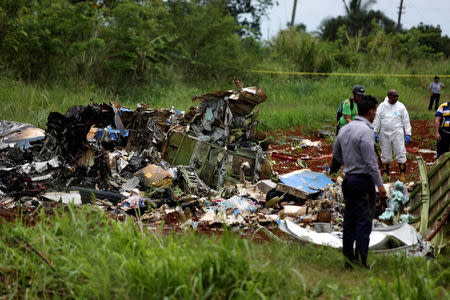Rescue team members work on the wreckage of a Boeing 737 plane that crashed in the agricultural area of Boyeros, some 20 km (12 miles) south of Havana on Friday shortly after taking off from Havana's main airport in Cuba, May 18, 2018. REUTERS/Alexandre Meneghini