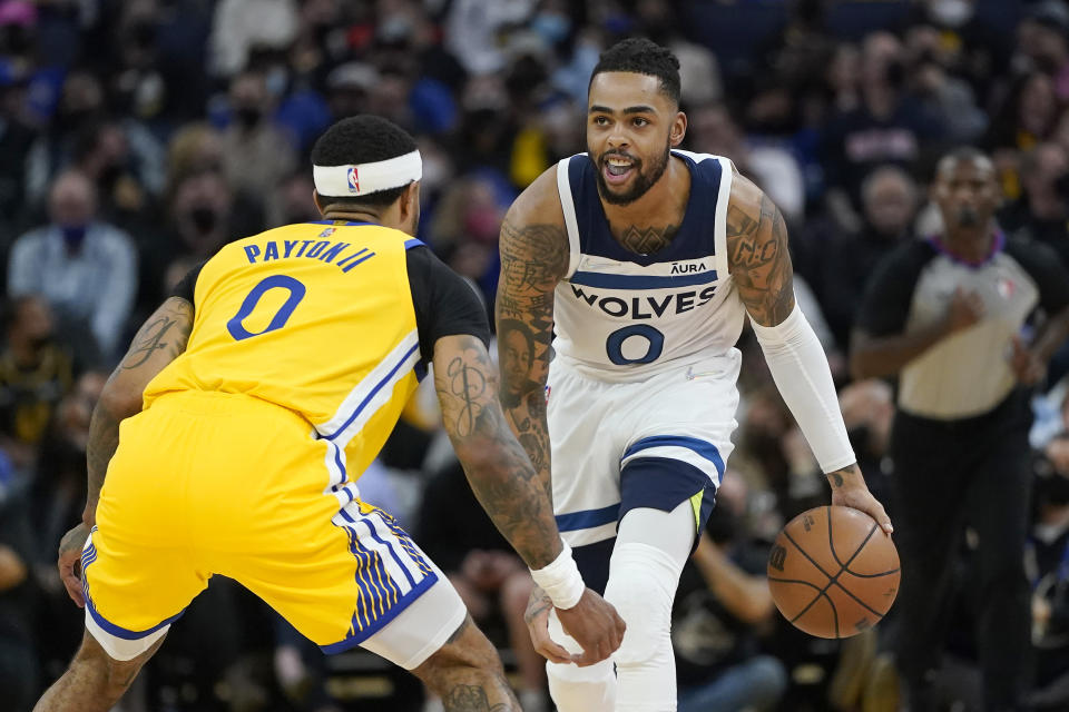 Minnesota Timberwolves guard D'Angelo Russell, right, dribbles the ball up the court against Golden State Warriors guard Gary Payton II during the first half of an NBA basketball game in San Francisco, Thursday, Jan. 27, 2022. (AP Photo/Jeff Chiu)