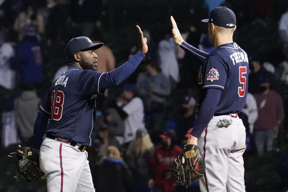 Atlanta Braves' Guillermo Heredia, left, celebrates with Freddie Freeman after they defeated the Chicago Cubs in a baseball game in Chicago, Sunday, April 18, 2021. (AP Photo/Nam Y. Huh)