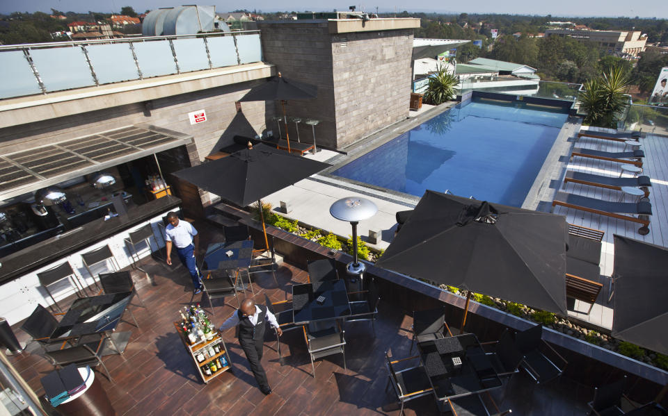 FILE - A member of staff wheels drinks at the rooftop pool of the Sankara Nairobi hotel in Nairobi, Kenya on Sept. 26, 2012. The ballooning debt in East Africa's economic hub of Kenya is expected to grow even more after deadly protests forced the rejection of a finance bill that President William Ruto said was needed to raise revenue. (AP Photo/Ben Curtis, File)