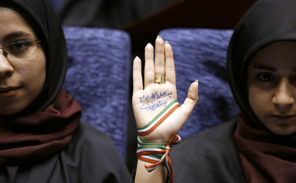 <p>A supporter of Iranian conservative presidential candidate and Tehran mayor Mohammad Bagher Ghalibaf, holds up her hand, wrapped with a ribbon in the colors of the Iranian flag, as she attends a campaign rally in Tehran, Iran, May 14, 2017 (Photo: Atta Kenare/AFP/Getty Images) </p>