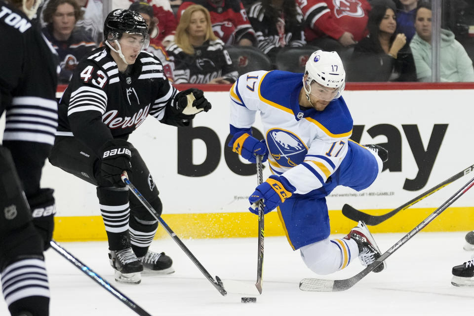 Buffalo Sabres center Tyson Jost (17) passes against New Jersey Devils defenseman Luke Hughes (43) during first period of an NHL hockey game, Tuesday, April 11, 2023, in Newark, N.J. (AP Photo/John Minchillo)