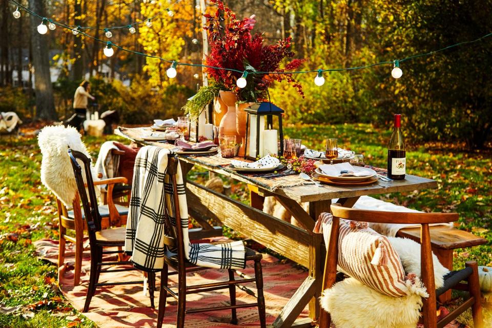 <p>If you're lucky enough to be celebrating Thanksgiving outdoors this year, take full advantage of what nature has to offer. For your centerpiece, add foliage in tall vases and a chic lantern for warmth. </p>