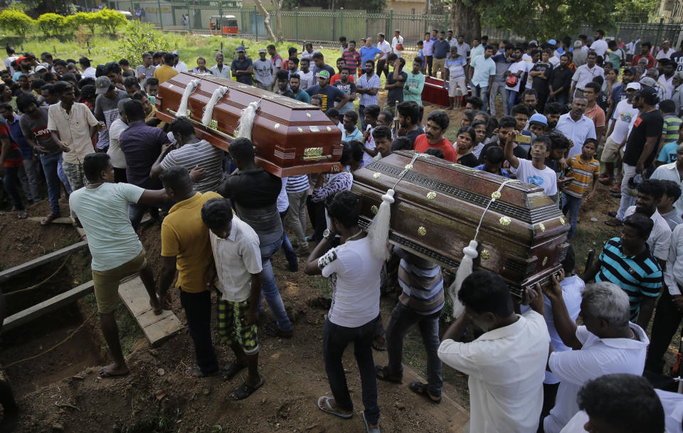 Sri Lankans carry the coffins with the remains of Berington Joseph, left, and Burlington Bevon, right, who were killed in the Easter Sunday bombings in Colombo, Sri Lanka, Tuesday, April 23, 2019. The six near-simultaneous attacks on three churches and three luxury hotels and three related blasts later Sunday were the South Asian island nation's deadliest violence in a decade while Sri Lanka police arrested 40 suspects in the wake of a state of emergency that took effect Tuesday giving the military war-time powers. (AP Photo/Eranga Jayawardena)