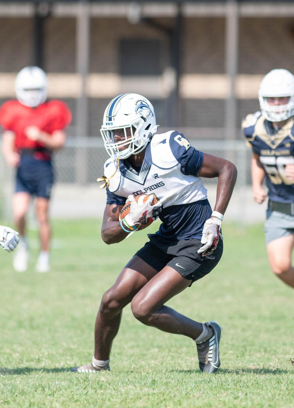 KT Randle (1) carries the ball during football practice at Gulf Breeze High School on Thursday, Aug. 3, 2023.