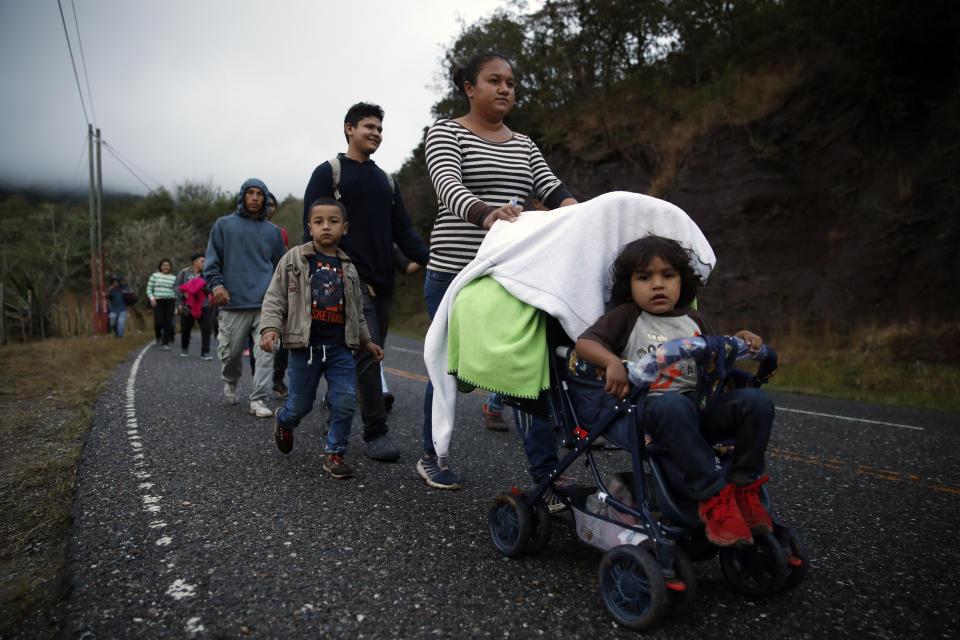 Honduran migrants walk north along a road in hopes of reaching the distant United States, as they leave Esquipulas, Guatemala, just after sunrise Friday, Jan. 17, 2020. The group departed San Pedro Sula on Jan. 15. (AP Photo/Moises Castillo)