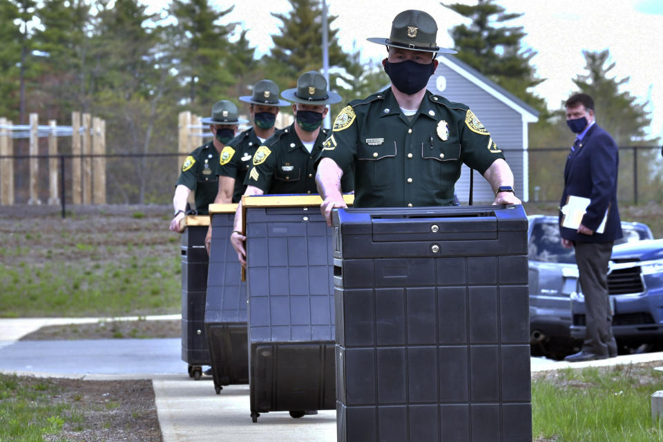 FILE - In this May 11, 2021 file photo, N.H. State Troopers deliver ballot counting machine bases to a National Guard Training area in Pembroke, N.H., which is the site of a forensic audit of a New Hampshire legislative election. Auditors concluded in a report released Tuesday, July 13, 2021, that miscounts in a New Hampshire election were caused by the way ballots were folded. (AP Photo/Josh Reynolds, File)