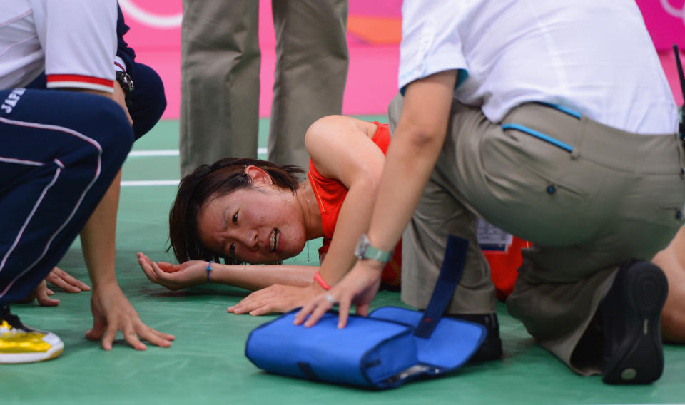 LONDON, ENGLAND - AUGUST 01: Sayaka Sato of Japanlies injured before withdrawing with an injury against Tine Baun of Denmark in their Women's Singles Badminton on Day 5 of the London 2012 Olympic Games at Wembley Arena at Wembley Arena on August 1, 2012 in London, England. (Photo by Michael Regan/Getty Images)