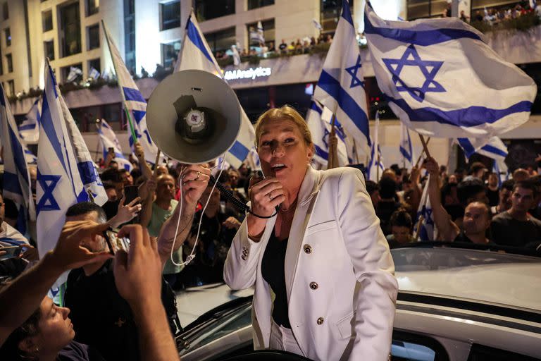 La ex ministra de Relaciones Exteriores de Israel, Tzipi Livni, habla a través de un megáfono mientras está rodeada de manifestantes que bloquean una carretera durante una manifestación contra el plan de reforma judicial del gobierno israelí en Tel Aviv el 24 de julio de 2023.