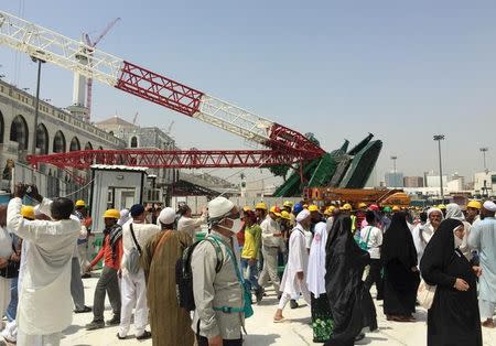 Muslim pilgrims walk near a construction crane which crashed in the Grand Mosque in the Muslim holy city of Mecca, Saudi Arabia September 12, 2015. REUTERS/Mohamed Al Hwaity