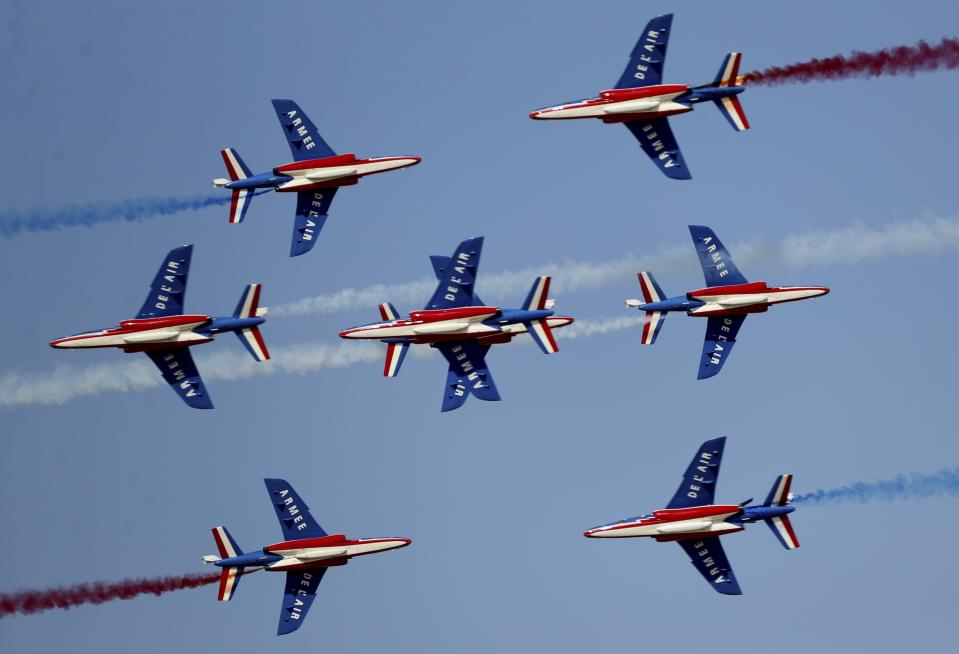 French aircrafts of the Patrouille de France spray colored smoke during a performance on the opening day of the Dubai Airshow in Dubai, United Arab Emirates, Sunday, Nov. 17, 2019. (AP Photo/Kamran Jebreili)