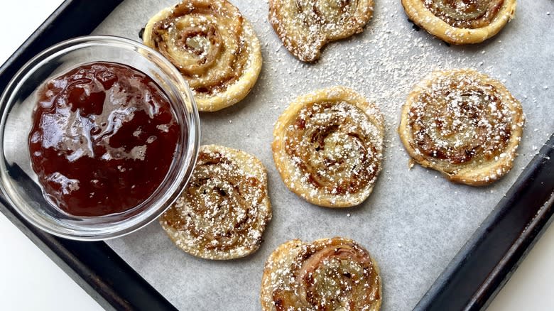 Monte Cristo Pinwheels on a baking sheet dusted with confectioners sugar