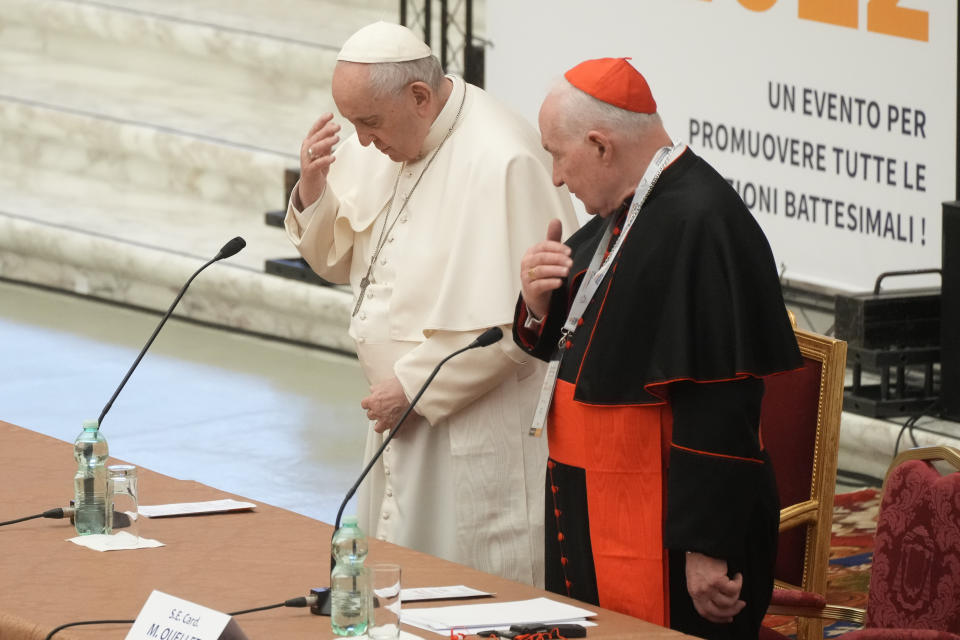Pope Francis, left, and Cardinal Marc Ouellet make the sign of the cross as they attend the opening of a 3-day Symposium on Vocations in the Paul VI hall at the Vatican, Thursday, Feb. 17, 2022. (AP Photo/Gregorio Borgia)