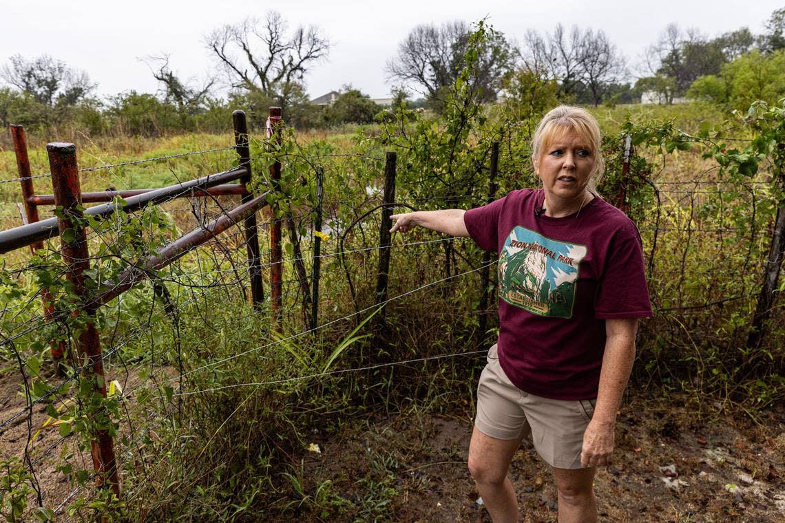 Springtown resident Cynthia Courtney points to the area where runoff streams into her backyard. Courtney has dealt with flooding since the D.R. Horton subdivision was built behind her property in 2023. According to Courtney, the construction has disrupted the natural drainage pattern and has since caused substantial flooding in and around her home.