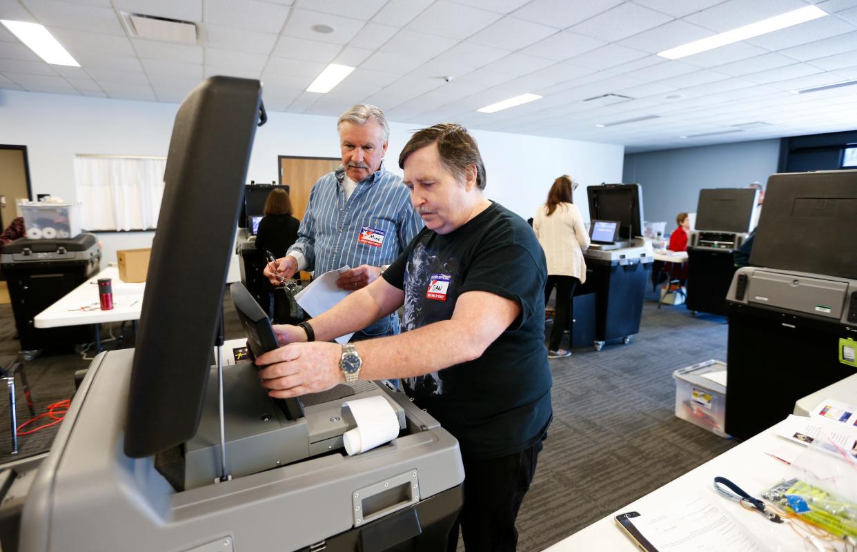 Daniel Cook (right) and Mike Schoonmaker verify a voting machine before sealing it at the Greene County Elections Center on Friday, Feb. 28, 2020.