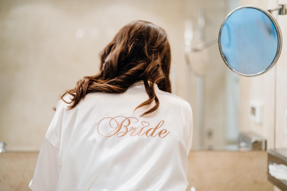 bride getting ready in white getting ready gown