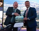 Boeing Commercial Airplanes president and CEO Stanley A. Deal, left, shakes hands with SunExpress CEO Jens Bischof, at the Dubai Airshow in Dubai, United Arab Emirates, Monday, Nov. 18, 2019. The Turkish-German airline SunExpress announced Monday it will be buying 10 of the troubled Boeing 737-8 Max jets, grounded globally after crashes, in a deal worth $1.2 billion. (AP Photo/Jon Gambrell)