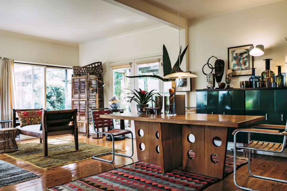 A simple timber-and-tin cottage on the coast of New South Wales, Australia, houses a mix of 20th-century furnishings and one-of-a-kind artifacts curated by furniture restorer and retailer Rodney de Soos and Patrick Carrick. “Letting someone in your house is like letting them read your diary; your obsessions become apparent quite quickly,” says De Soos. Here, a teak table from India is juxtaposed against a steel cabinet topped with a collection of Scandinavian glass.