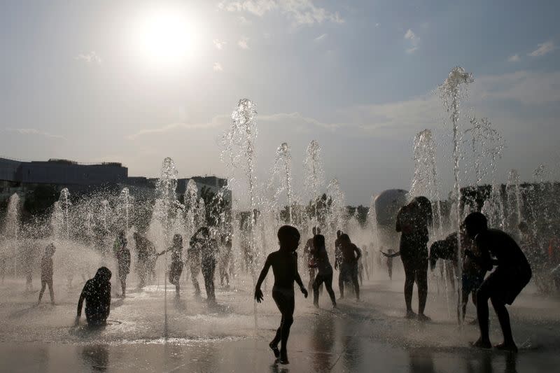 Imagen de archivo de personas refrescándose en las fuentes de agua de un parque, en momentos de altas temperaturas en París