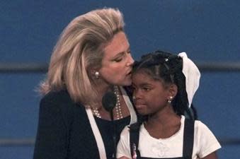 FILE –<em> AIDS activist Mary Fisher kisses 12-year-old Hydeia Broadbent, a youngster who also has AIDS as they were both addressing the evening session of the 1996 GOP convention in San Diego Monday, Aug. 12, 1996.</em> (AP Photo/Ron Edmonds, File)