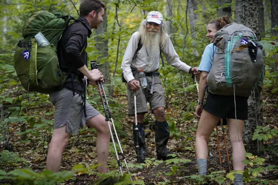 M.J. Eberhart, 83, center, shares trail information with a pair of thru-hikers on the Appalachian Trail, Sunday, Sept. 12, 2021, in Gorham, New Hampshire. Eberhart, who goes by the trail name of Nimblewill Nomad, is the oldest person to hike the entire 2,193-mile Appalachian Trail. (AP Photo/Robert F. Bukaty)