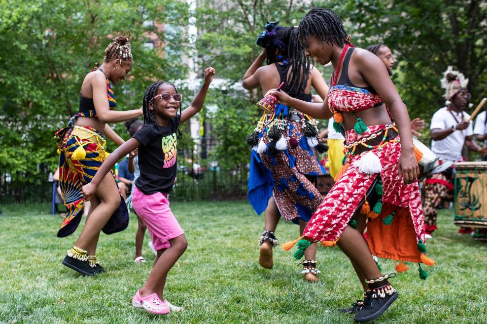 Kylee Muhammad, 6, of Detroit, center, dances with her sister Kaniyah Fulton, of Detroit, right, of Solid Foundation Cultural Arts during Freedom Day Celebration at the Capitol Park in Detroit on Wednesday, June 19, 2024.