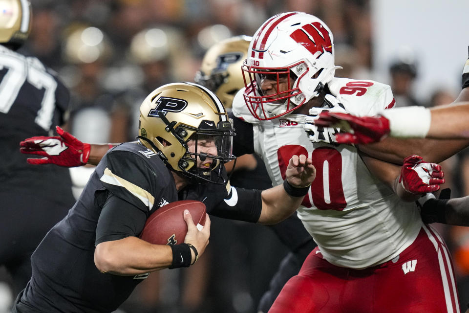 Wisconsin defensive end James Thompson Jr. (90) sacks Purdue quarterback Hudson Card (1) during the first half of an NCAA college football game in West Lafayette, Ind., Friday, Sept. 22, 2023. (AP Photo/Michael Conroy)