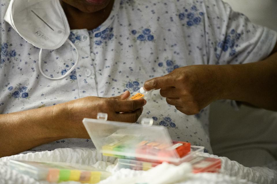 Theresa Mozzee, 59, takes her daily medication in bed before having a meal. In December, a doctor said her respiratory illness might be caused by exposure to mold. She also is a lupus and cancer patient. Mold and vermin forced her to move out of a public housing unit in Charleston, South Carolina.