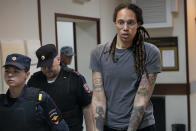 FILE - WNBA star and two-time Olympic gold medalist Brittney Griner is escorted from a courtroom after a hearing in Khimki just outside Moscow, on Aug. 4, 2022. Russia has freed WNBA star Brittney Griner on Thursday in a dramatic high-level prisoner exchange, with the U.S. releasing notorious Russian arms dealer Viktor Bout. (AP Photo/Alexander Zemlianichenko, File)