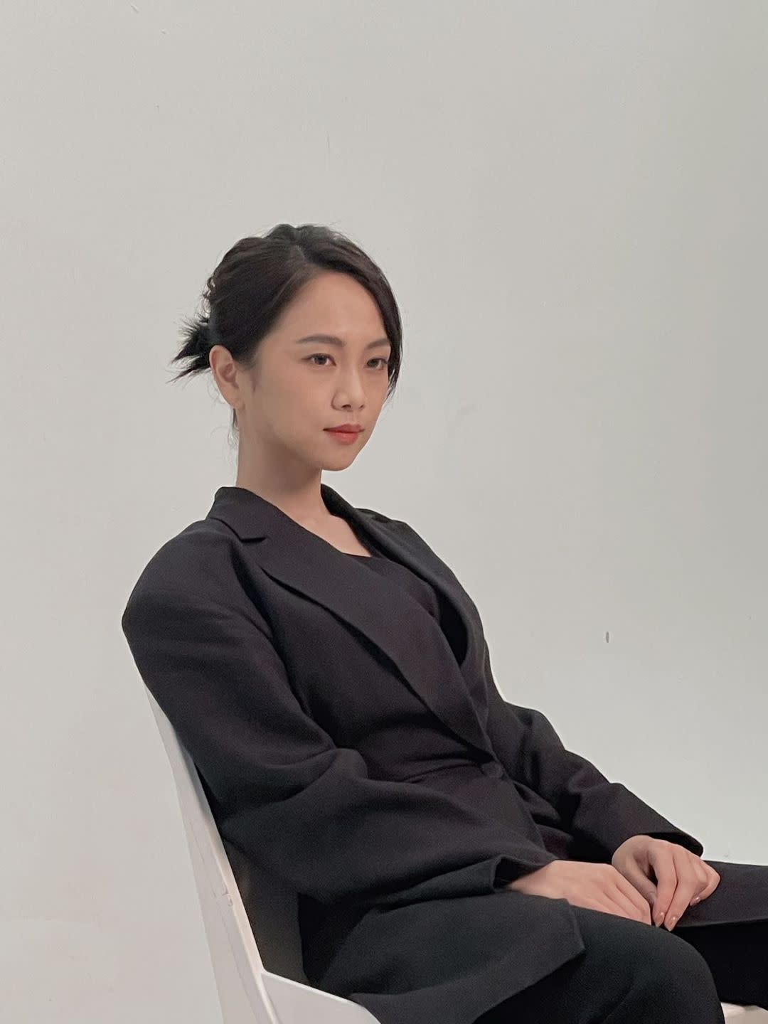 apede mode's founder sits in a chair wearing a black suit