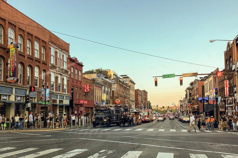 Crowds of people walking past the bars and Venues lining Broadway Street in downtown Nashville, Tennessee.