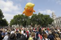 <p>Activists inflate a giant balloon depicting US President Donald Trump as an orange baby during a demonstration against Trump’s visit to the UK in Parliament Square in London on July 13, 2018. (Photo: Tolga Akmen/AFP/Getty Images) </p>