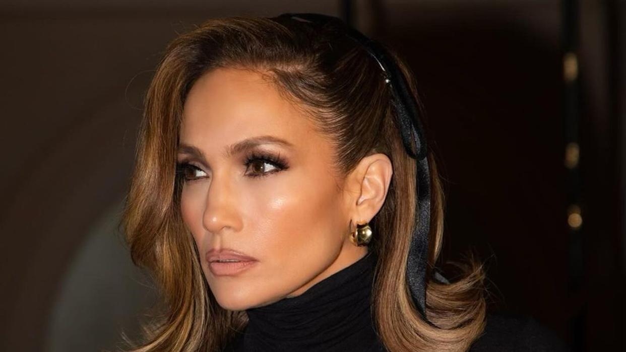 Jennifer Lopez shares an image of her hairstyle to her Instagram. She wears a black turtleneck under a white corset top