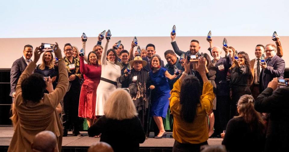 The 20 Top Latino Change Makers pose for photos holding their awards at an event at Sacramento State on Friday night.